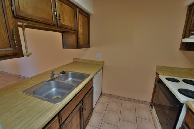 kitchen featuring light tile patterned floors, sink, white appliances, and range hood