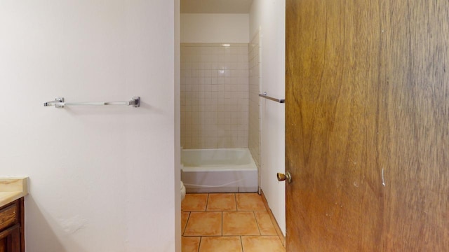 bathroom featuring tiled shower / bath combo, tile patterned flooring, and vanity