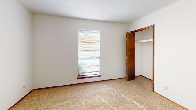 unfurnished bedroom with a textured ceiling and light carpet