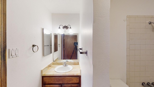 bathroom featuring a tile shower and vanity