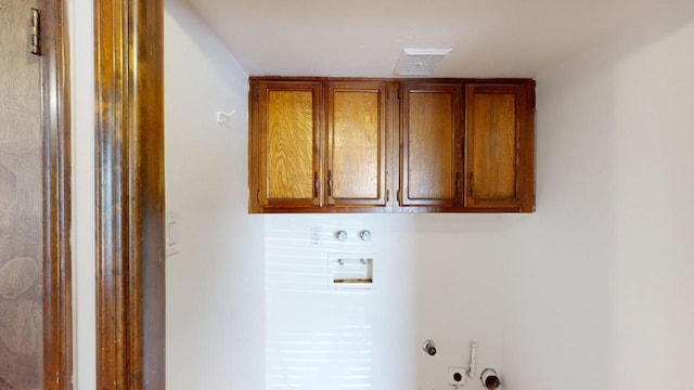 clothes washing area with hookup for a washing machine, cabinets, and hookup for a gas dryer