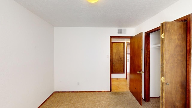 carpeted empty room featuring a textured ceiling