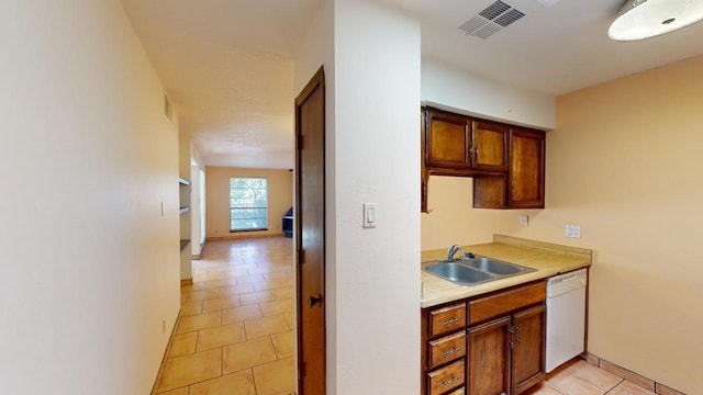 kitchen with light tile patterned floors, dishwasher, and sink