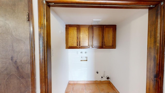 laundry area with gas dryer hookup, light tile patterned flooring, washer hookup, and cabinets