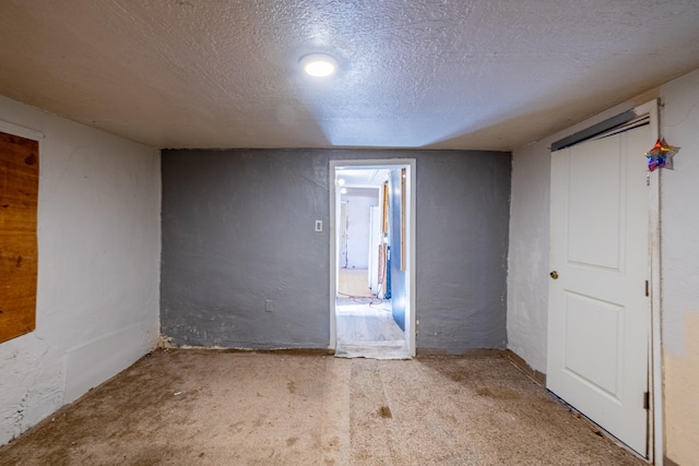 spare room featuring light carpet and a textured ceiling