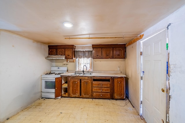 kitchen with sink, light tile floors, and white gas range oven