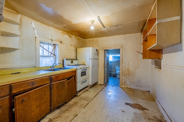 kitchen featuring white appliances, sink, and light tile floors