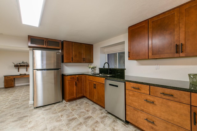 kitchen featuring appliances with stainless steel finishes, sink, and dark stone counters