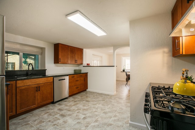 kitchen featuring sink, stainless steel dishwasher, gas stove, and premium range hood