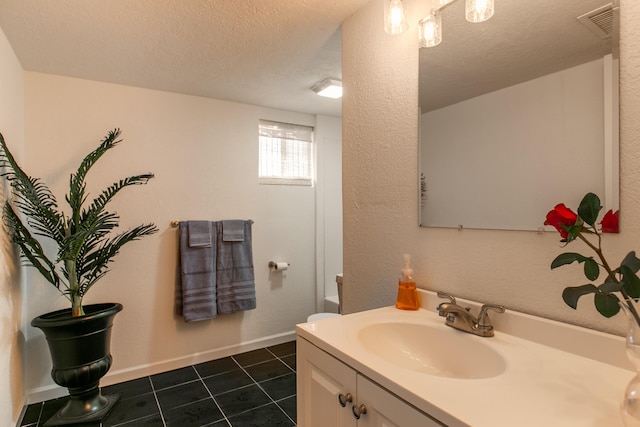 bathroom featuring vanity, tile patterned floors, and a textured ceiling