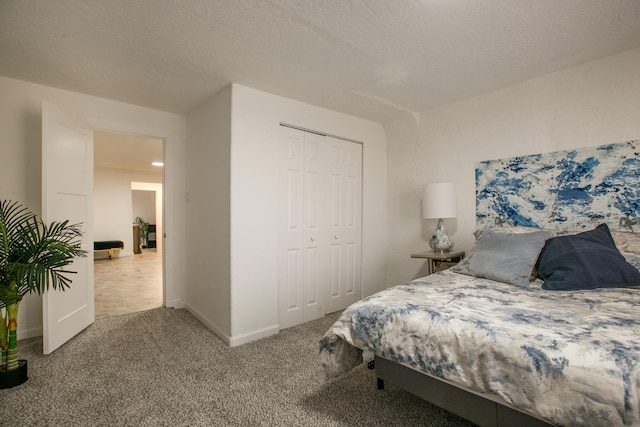 bedroom featuring a closet, a textured ceiling, and carpet