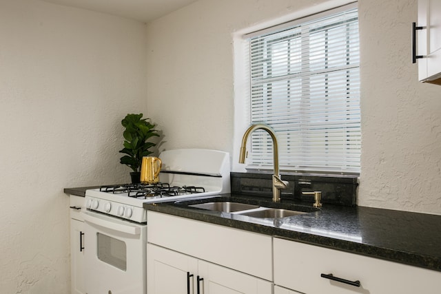 kitchen with white cabinetry, sink, and white range with gas stovetop