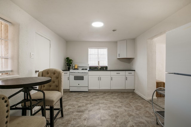 kitchen with white cabinetry, white appliances, and sink