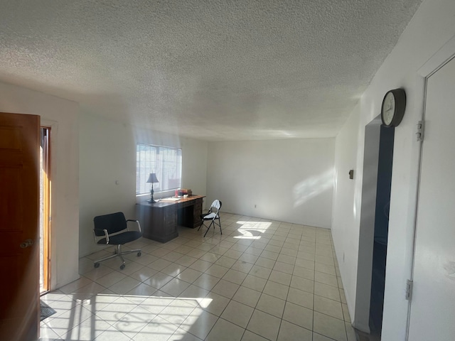 unfurnished office with light tile floors and a textured ceiling