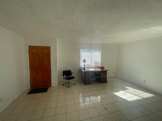 interior space featuring a textured ceiling and light tile floors