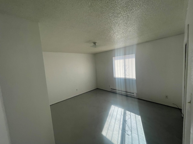 unfurnished room with baseboard heating and a textured ceiling