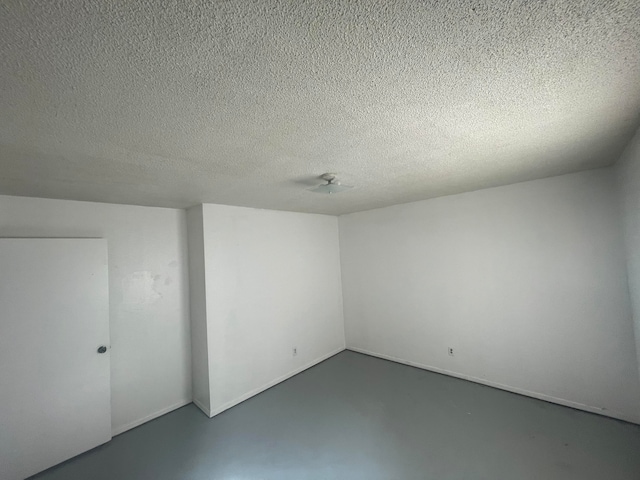 spare room featuring concrete floors and a textured ceiling