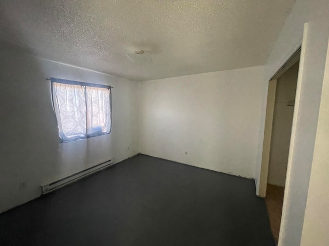 unfurnished room featuring a baseboard radiator and a textured ceiling