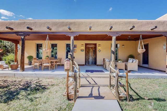 entrance to property featuring a patio area and stucco siding