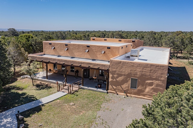 112 Ten Pines Rd, Torreon, NM 87061 - back of property with a patio and a wooded view