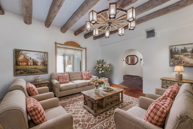 living room featuring arched walkways, a notable chandelier, visible vents, wood finished floors, and beamed ceiling