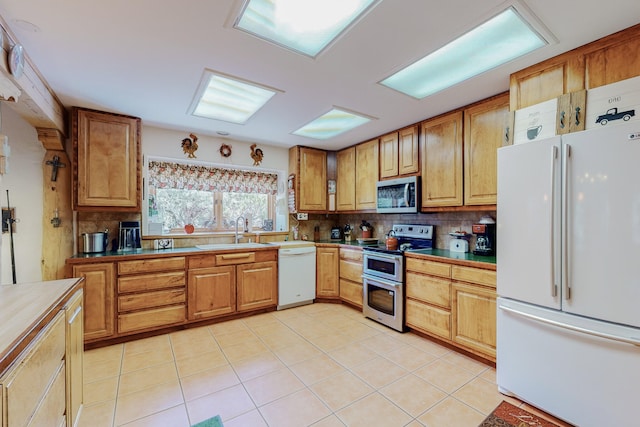 112 Ten Pines Rd, Torreon, NM 87061 - kitchen with appliances with stainless steel finishes, a sink, tasteful backsplash, and light tile patterned floors