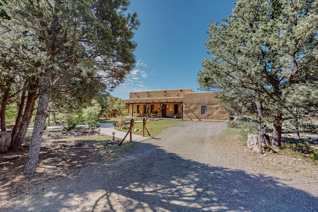 112 Ten Pines Rd, Torreon, NM 87061 - pueblo revival-style home with stucco siding and a patio