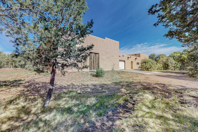 exterior space featuring driveway, an attached garage, and stucco siding