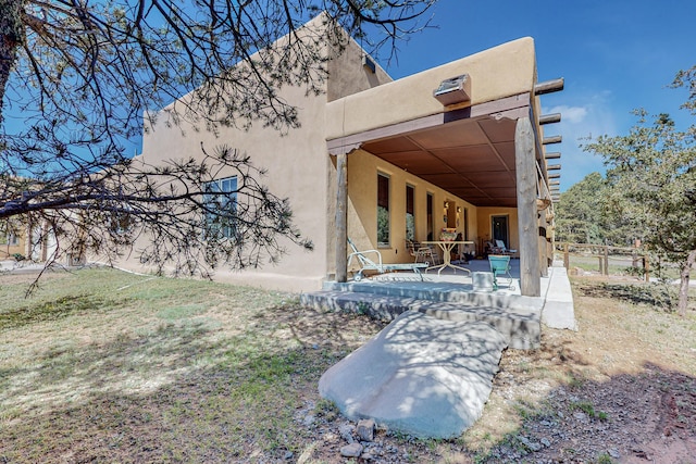 back of property with a patio and stucco siding