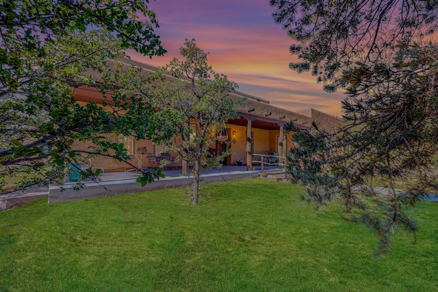 112 Ten Pines Rd, Torreon, NM 87061 - back of property at dusk with a lawn and a patio area