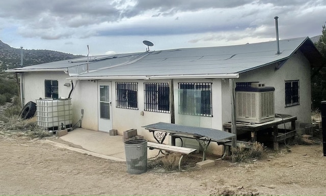 back of house featuring central air condition unit, a patio area, and a mountain view