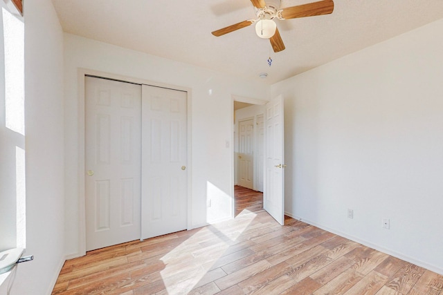 unfurnished bedroom featuring ceiling fan, a closet, and light hardwood / wood-style floors