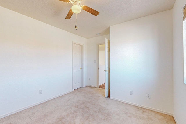 unfurnished bedroom featuring a textured ceiling, ceiling fan, and light colored carpet