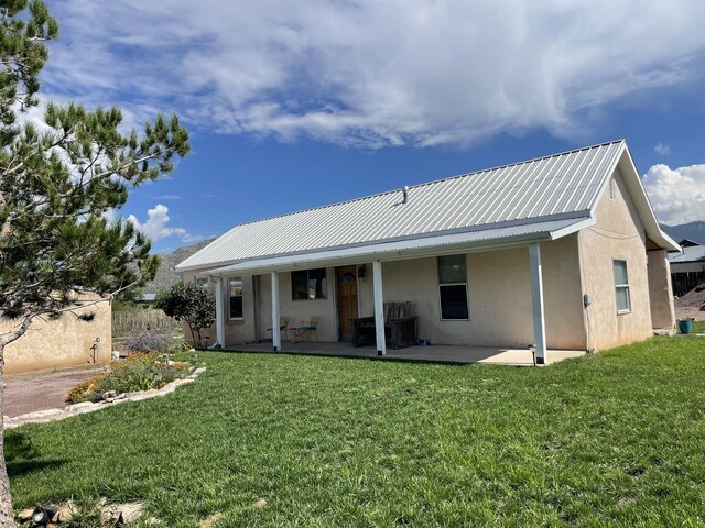 rear view of property featuring a lawn