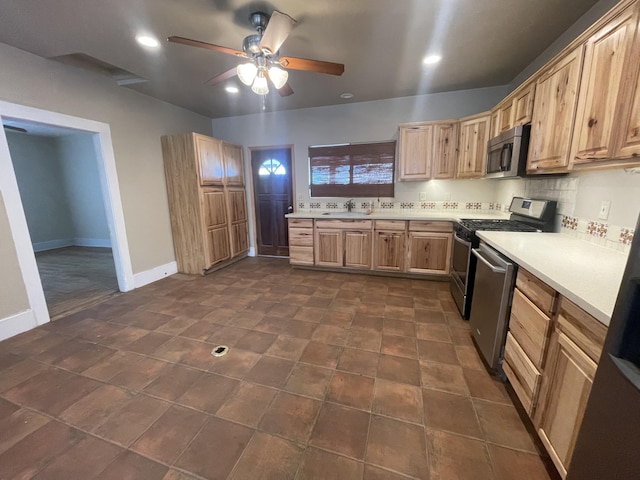 kitchen with tasteful backsplash, appliances with stainless steel finishes, sink, and ceiling fan