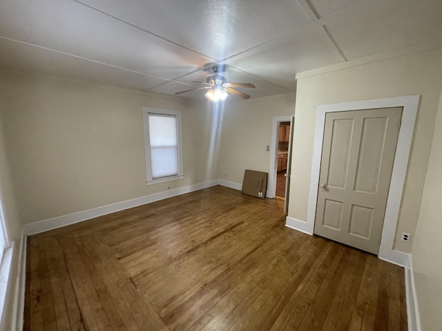 unfurnished bedroom with crown molding, dark wood-type flooring, and ceiling fan