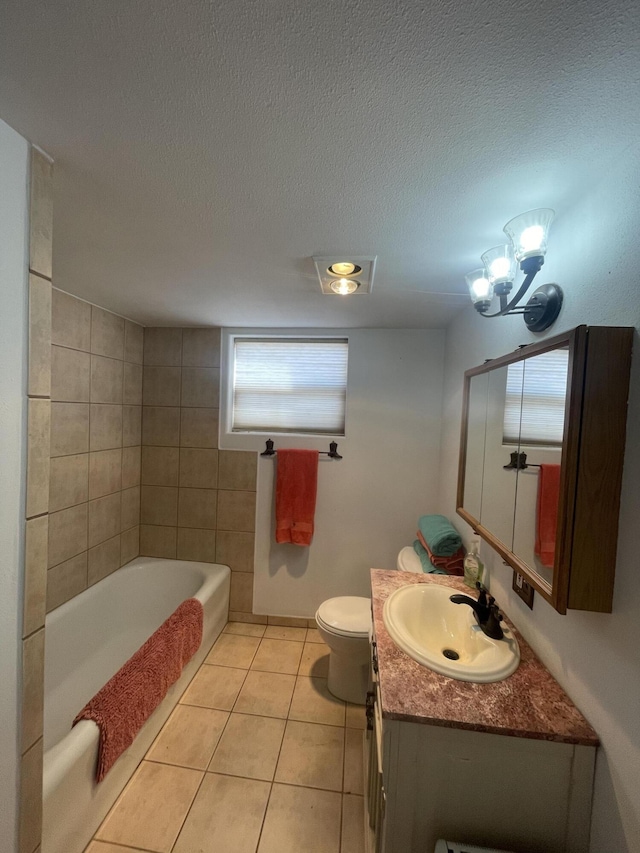 bathroom featuring vanity, a tub, tile patterned floors, and a textured ceiling