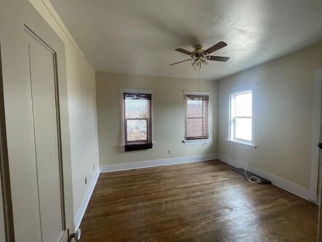 empty room featuring dark wood-type flooring and ceiling fan