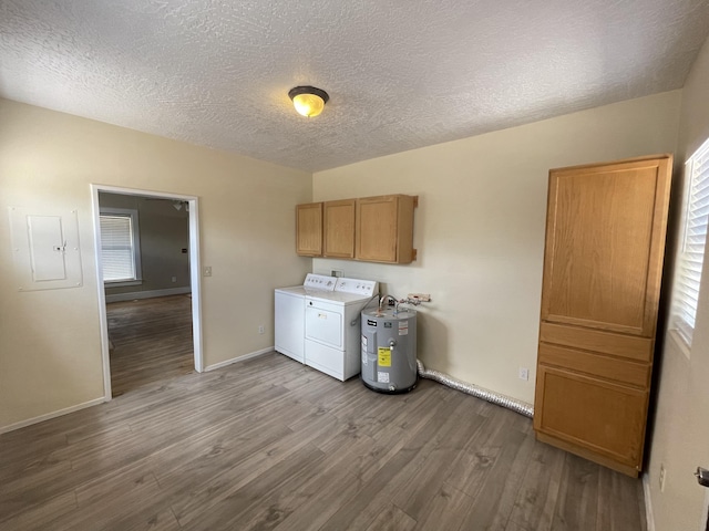 clothes washing area with washer and clothes dryer, water heater, hardwood / wood-style floors, electric panel, and cabinets