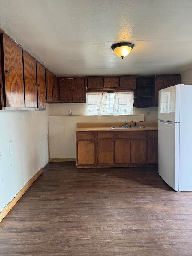 kitchen featuring sink, white refrigerator, and dark hardwood / wood-style floors