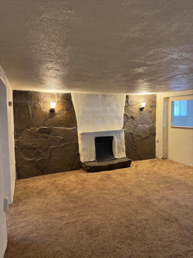 basement with a fireplace, carpet, and a textured ceiling