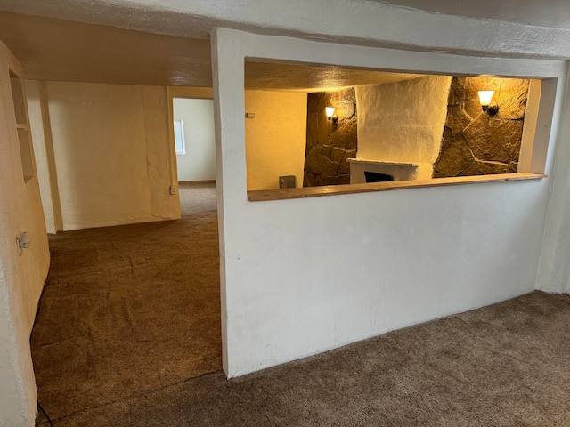 basement featuring dark colored carpet and a textured ceiling