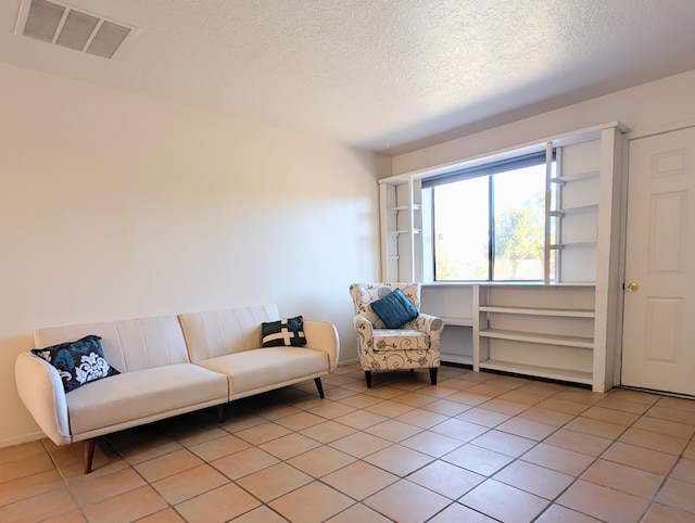 sitting room featuring a textured ceiling and light tile patterned flooring