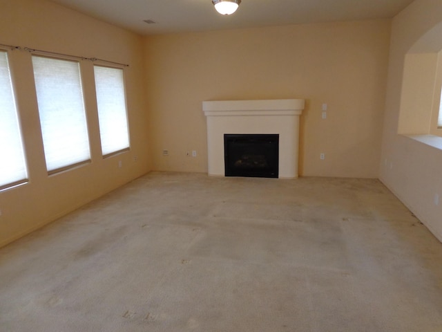 unfurnished living room featuring light colored carpet