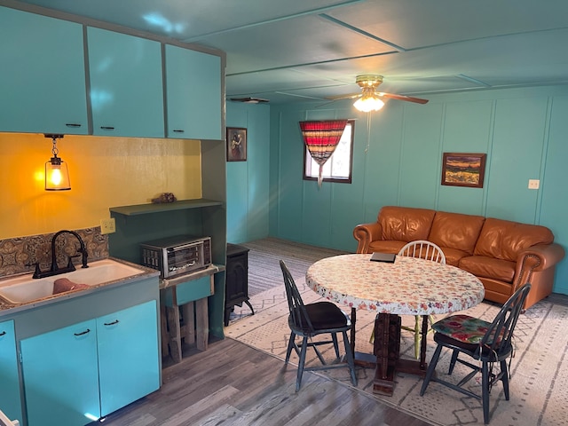 dining area with sink, ceiling fan, and dark hardwood / wood-style flooring