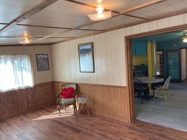 sitting room with hardwood / wood-style flooring, wooden walls, wooden ceiling, and ceiling fan