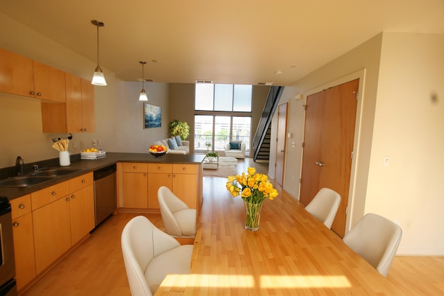 kitchen with pendant lighting, dishwasher, kitchen peninsula, light hardwood / wood-style flooring, and light brown cabinets