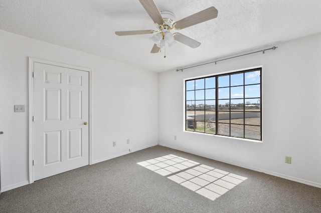 carpeted empty room featuring plenty of natural light, ceiling fan, and a textured ceiling