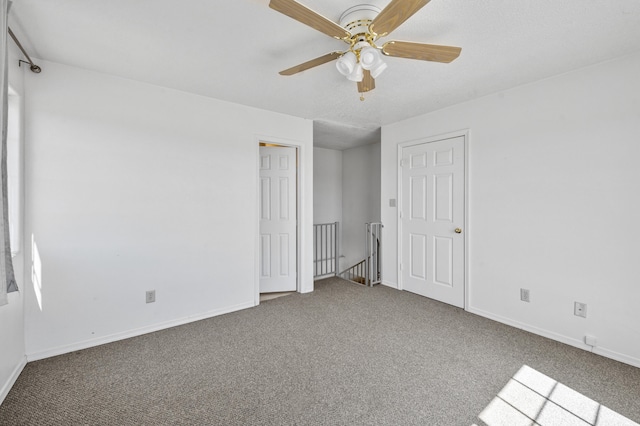 carpeted empty room featuring ceiling fan