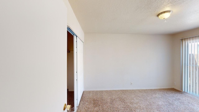 carpeted empty room with a textured ceiling